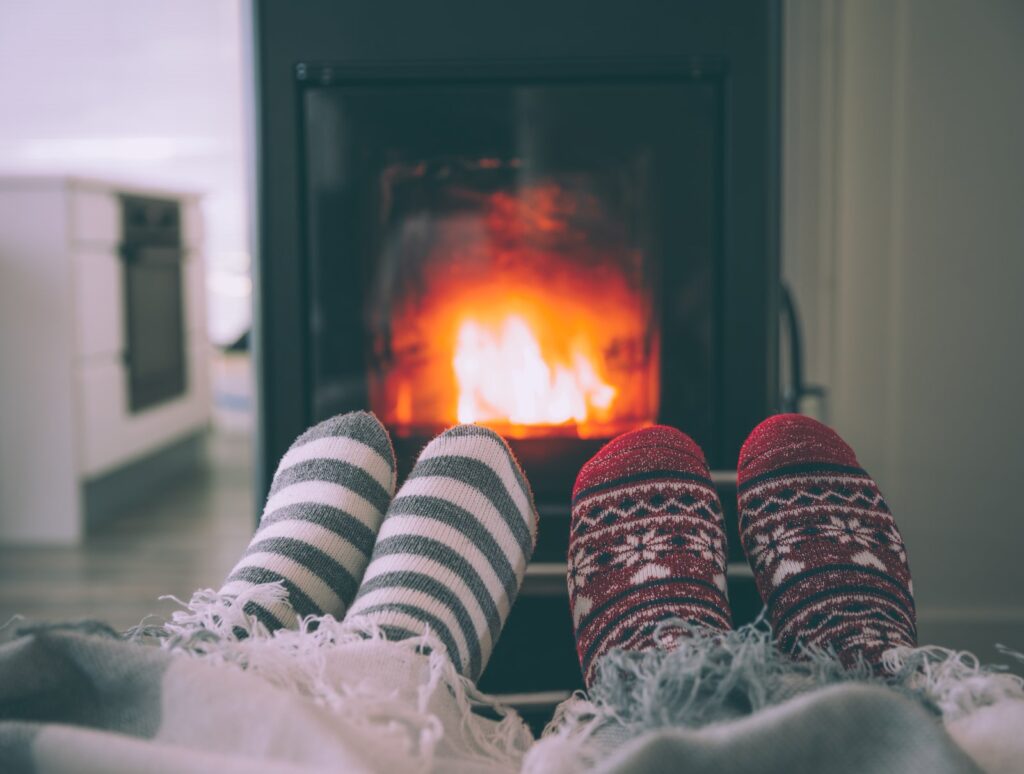 Feet woollen socks by fireplace